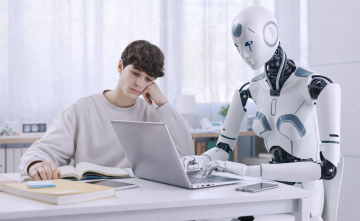 Mężczyzna i robot przy laptopie